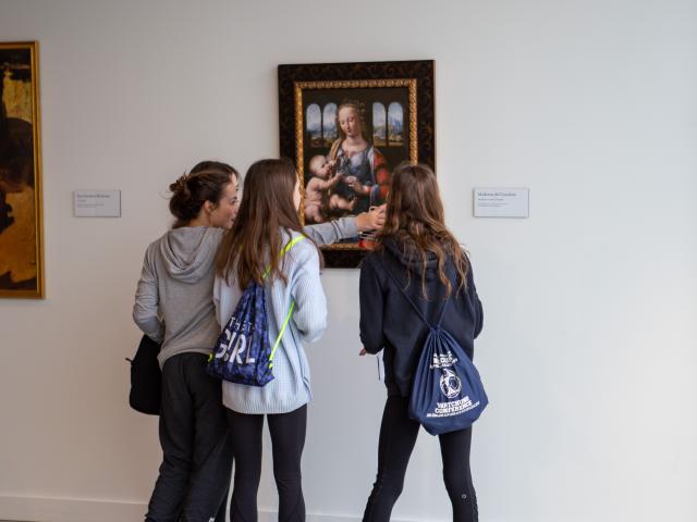 Fine arts students examine a painting