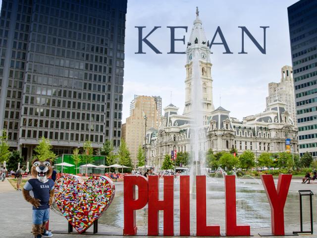 Kean University mascot posing beside a heart sculpture and large ‘PHILLY’ sign in front of Philadelphia City Hall.