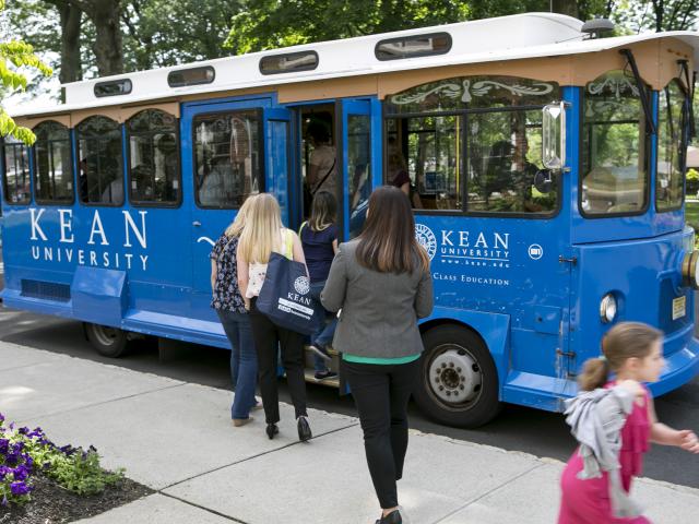 Kean Trolley (Blue, yellow white) on campus picking persons up